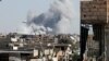 Smoke rises near the stadium where the Islamic State militants are holed up after an air strike by coalition forces at the frontline, in Raqqa, Oct. 12, 2017. 