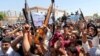 Iraqi men raise up weapons and shout slogans as they demonstration in the central Shiite Muslim shrine city of Najaf on June 14, 2014 to show their support for the call to arms by Shiite cleric Grand Ayatollah Ali al-Sistani. 
