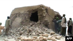 FILE - This file photo taken on July 1, 2012 shows a still from a video of Islamist militants destroying an ancient shrine in Timbuktu. The trial of a Malian jihadist charged with war crimes for ordering the 2012 destruction of 14 mausoleums of Muslim sai
