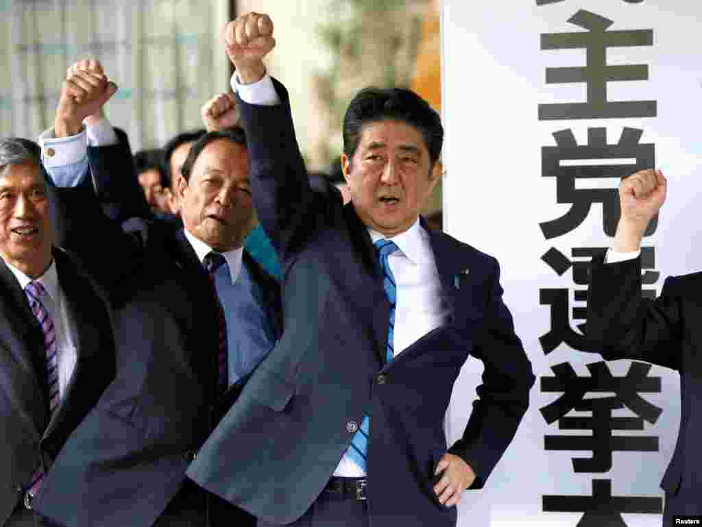 Japan&#39;s Prime Minister Shinzo Abe (3rd L) and his party&#39;s lawmakers raise their fists as they pledge to win in the upcoming lower house election, at their party headquarters in Tokyo.