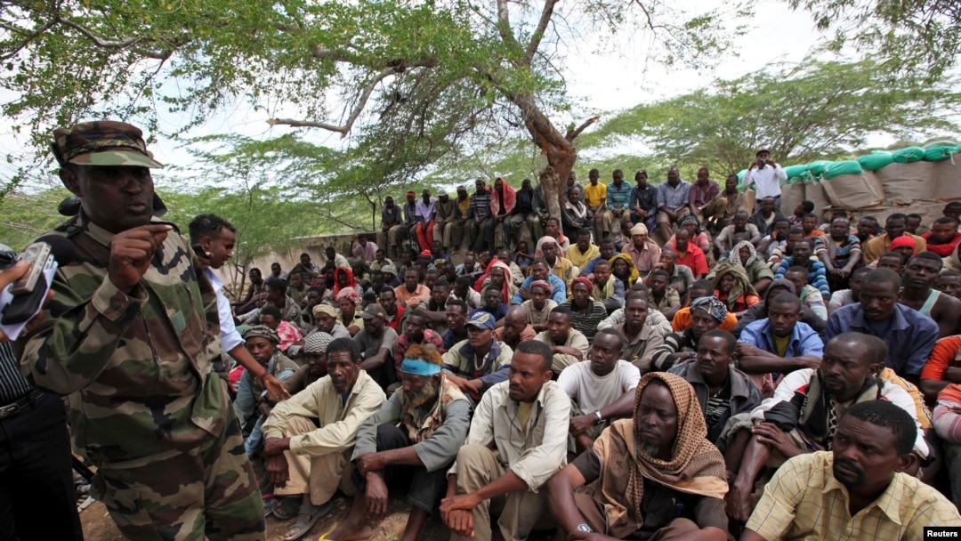 FILE - Members of the militant group al-Shabab listen to a Somalia government soldier after their surrender to the authorities in Mogadishu, Sept. 24, 2012.
