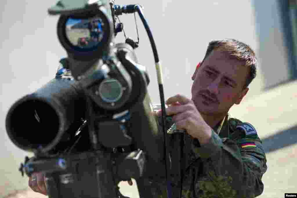 Nemis askari tanklarga qarshi raketa otuvchi quroldan qanday foydalanishni ko'rsatmoqda. Bu qurollar Iroq shimolidagi kurdlarga topshirilishi kutilmoqda, Berlin, 18-sentabr, 2014-yil.