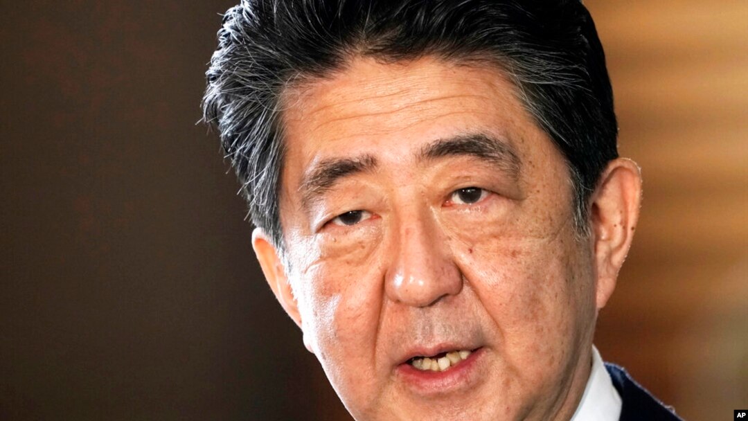 FILE - Japan's outgoing Prime Minister Shinzo Abe speaks to the media as he arrives at the prime minister's office for a Cabinet meeting in Tokyo on Sept. 16, 2020. 