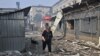 A woman passes by destroyed shops on a local market after a rocket attack in the Ukrainian town of Sloviansk, on July 3, 2022, amid the Russian invasion of Ukraine. 