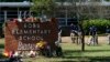 FILE - Investigators search for evidence outside Robb Elementary School in Uvalde, Texas, May 25, 2022, after an 18-year-old gunman killed 19 students and two teachers.