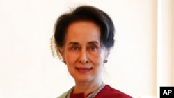 FILE - Myanmar's leader Aung San Suu Kyi receives a final report from Philippine diplomat Rosario Manalo, a member of the Independent Commission of Enquiry for Rakhine State, at the Presidential Palace in Naypyitaw, Myanmar on Jan. 20, 2020. 