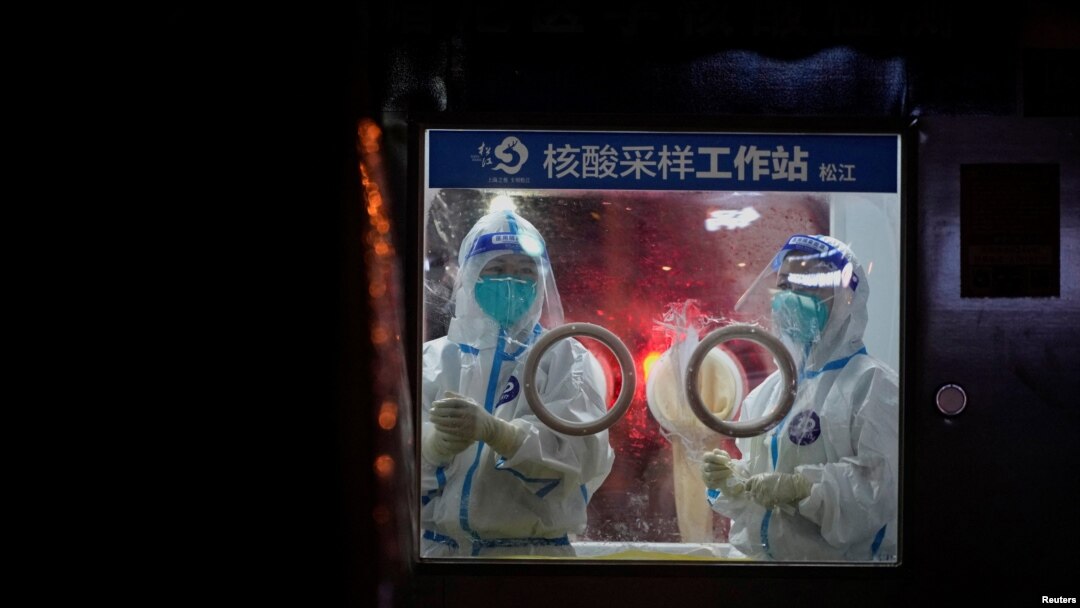 Medical workers in protective suits stand at a nucleic acid testing site in Shanghai, China, July 7, 2022. 
