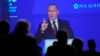Participants watch as Russian President Vladimir Putin addresses a plenary session of the St. Petersburg International Economic Forum in St. Petersburg, June 17, 2022. 