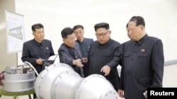 북한 김정은 노동당 위원장이 2017년 '핵무기 병기화 사업'을 현지지도하면서 핵탄두로 보이는 물체 앞에 서 있다.