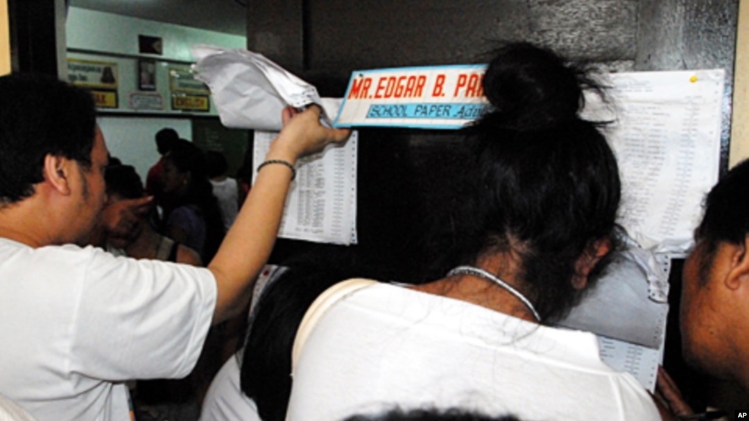 Voters check their papers at a polling station in the Philippine election