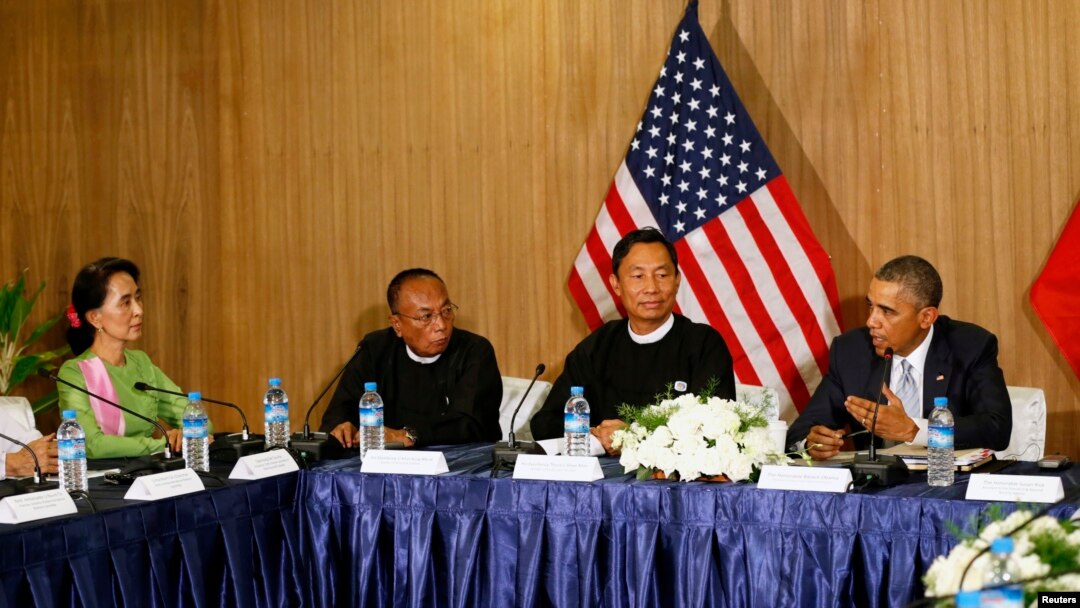 U.S. President Barack Obama speaks toward Myanmar opposition leader Aung San Suu Kyi (L) during a roundtable with members of parliament and civil society to discuss Myanmar's reform process in Naypyitaw, Nov. 13, 2014. 