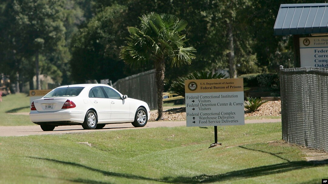 FILE - A car leaves the federal prison in Oakdale, La., Sept. 26, 2006. The federal Bureau of Prisons is locking up all its almost 150,000 inmates in their cells in an unparalleled effort to slow the spread of the coronavirus.