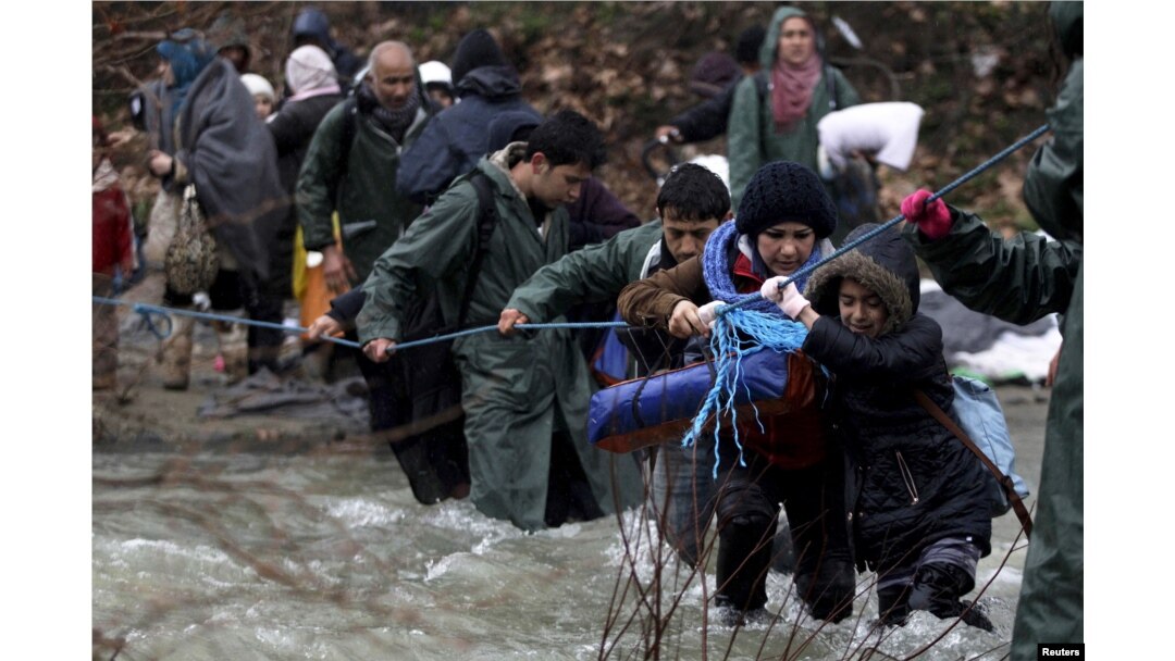 Refugees and migrants attempt to cross a river near the Greek-Macedonian border to enter Macedonia after an unsuccessful attempt yesterday, west of the village of Idomeni, Greece, March 15, 2016.