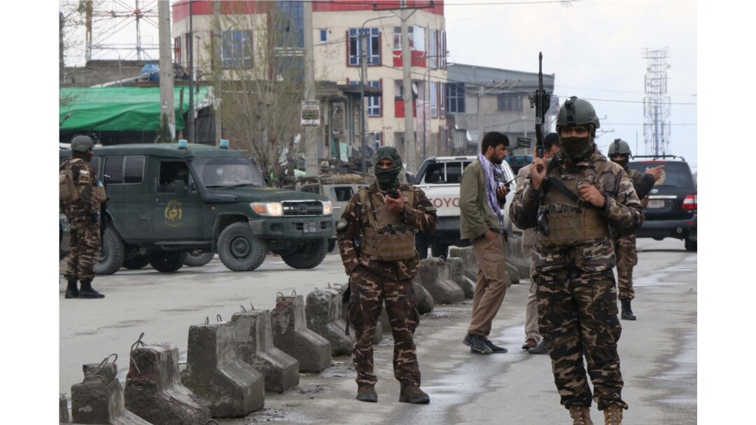 Afghan security personnel stand guard near the site of an attack to a Sikh temple in Kabul on March 25, 2020.