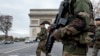 FILE - French soldiers cross the Champs Elysees avenue passing the Arc de Triomphe in Paris, Nov. 16, 2015. Prime Minister Manuel Valls says the government wants to prolong the current state of emergency set to expire May 26 to guarantee security for both the Euro 2016 football (soccer) championship and the Tour de France cycling race.