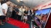 Jay Vandenbree, head of LG Electronics' U.S. consumer electronics business, fourth from right, gives consumers a look at the first Ultra-High-Definition TV to hit the U.S. market, an 84-inch LG model sold at Video & Audio Center in Lawndale, California, O