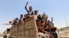 Volunteers, who have joined the Iraqi Army to fight against the predominantly Sunni ISIL militants, travel in army trucks in Baghdad June 14, 2014.