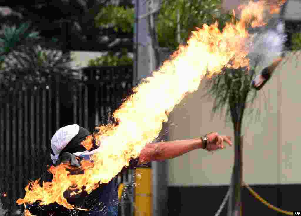 A student at the Autonomous National University of Honduras (UNAH) throws a Molotov cocktail at riot police during a protest demanding the resignation of Honduran President Juan Orlando Hernandez, on the second day of protests in Tegucigalpa, Jan. 28, 2019.