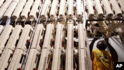 Verizon special service technician Mark Rose adjusts cables attached to a framework in a Verizon network room at the Main Post Office in New York. (File photo)