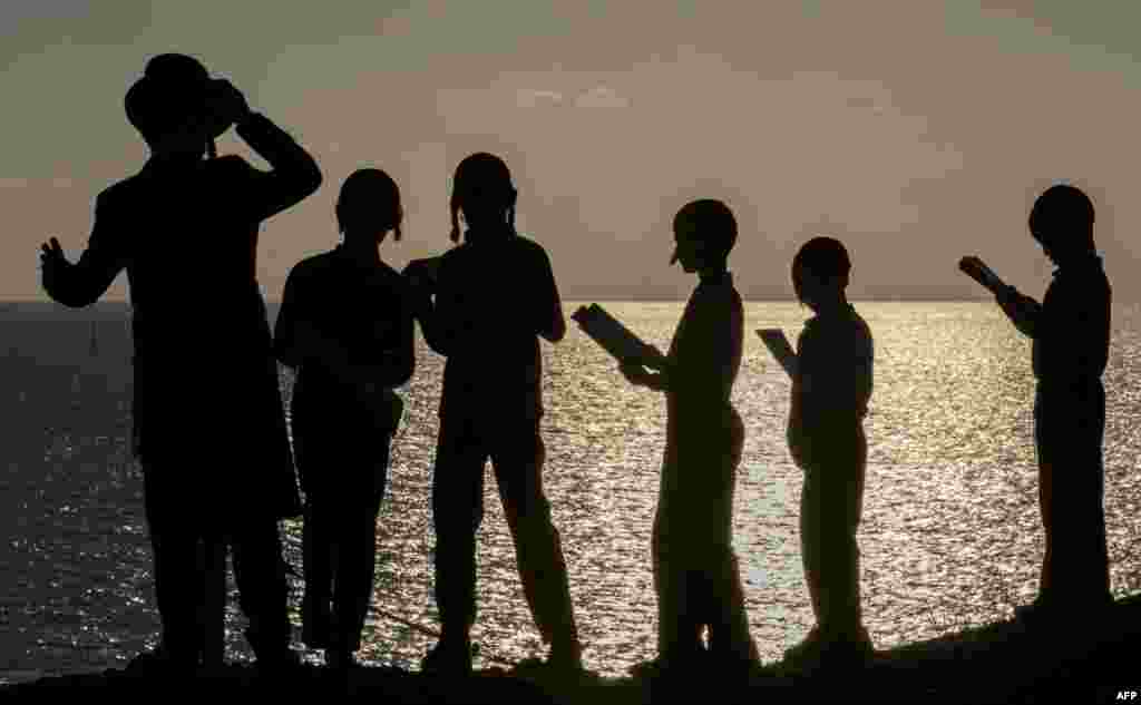 Ultra-Orthodox Jewish boys pray along the Mediterranean Sea in the Israeli city of Herzliya, near Tel Aviv, while performing the &quot;Tashlich&quot; ritual during which &quot;sins are cast into the water to the fish&quot;.
