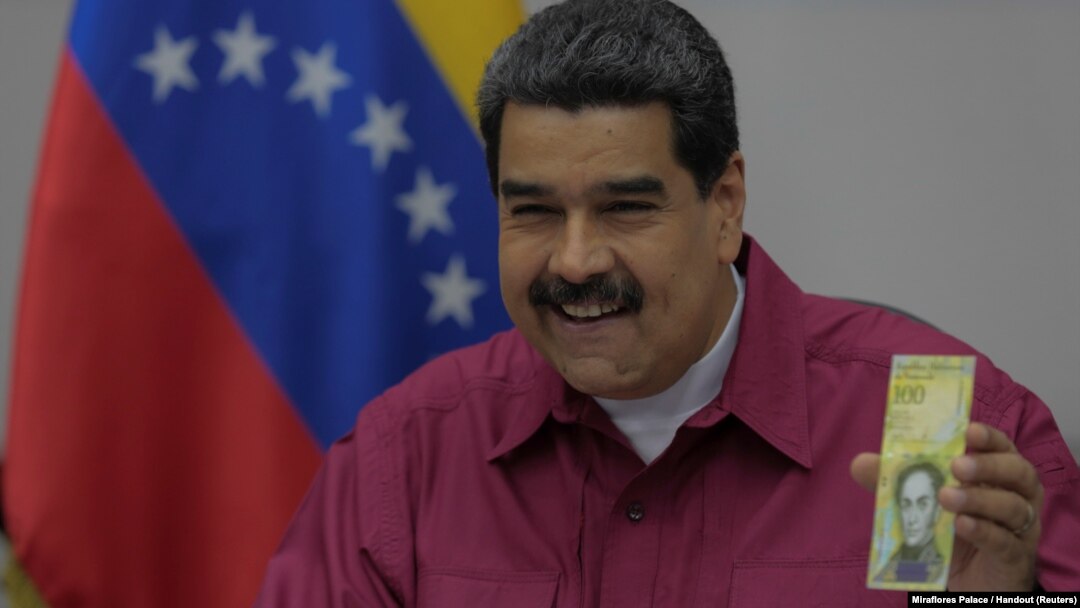 Venezuela's President Nicolas Maduro holds a 100,000 bolivar note as he speaks during a meeting with ministers in Caracas, Venezuela, Nov. 1, 2017. 