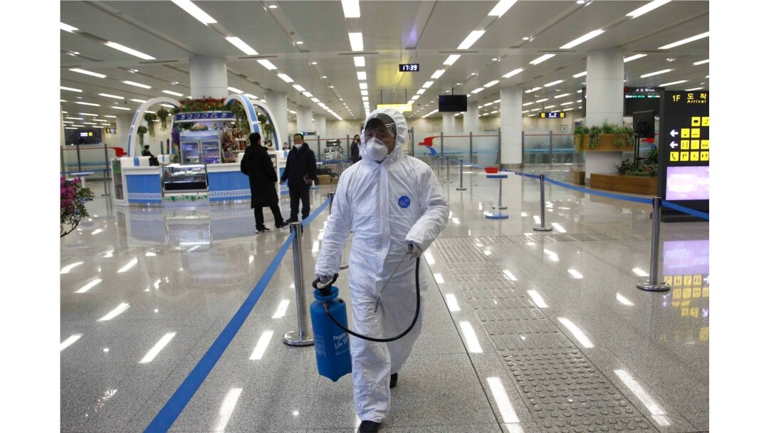 FILE - A State Commission of Quality Management staff member carries a disinfectant spray can as checks are done to inspect and quarantine goods being delivered via the borders at the Pyongyang Airport in Pyongyang, North Korea, Feb. 1, 2020.