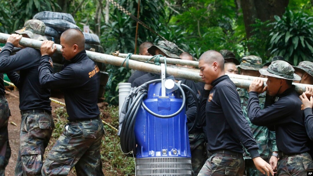 Soldiers carry a pump to help drain the rising floodwater in a cave where 12 boys and their soccer coach have been trapped since June 23, in Mae Sai, Chiang Rai province, in northern Thailand, July 6, 2018. 