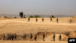 2023年10月27日,以色列军队士兵在以色列南部斯德洛特附近的加沙地带边界上行走,与此同时,以色列和哈马斯之间的战斗仍在继续。(法新社)
