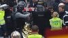 Hooded police officers detain a man in Saint-Denis, near Paris, after a raid on an apartment where the suspected mastermind of last week's terror attacks in the French capital was believed to have been holed up, Nov. 18, 2015.