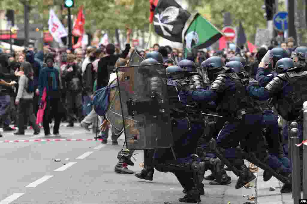 Anti-riot police charge protesters on the sidelines of a demonstration in Paris, part of a nationwide strikes and demonstrations day called by nine unions representing 5,4 million public sector workers to show their &quot;profound disagreement&quot; with French president&#39;s bid to transform the gargantuan public service and government&#39;s plans to freeze their pay and eliminate 120,000 public jobs.