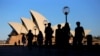 FILE - People walk in front of the Sydney Opera House, Australia, Nov. 2, 2016.