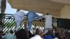 Unidentified lawmakers scale the parliament gate, in Abuja, Nigeria. Nov. 20, 2014.
