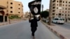 FILE - A supporter waves the flag of the Islamic State in Raqqa, Syria.