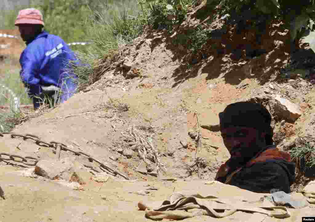 A suspected illegal miner climbs out of a ventilation shaft used to access an abandoned gold shaft in Benoni, east of Johannesburg, South Africa, Feb. 17, 2014.&nbsp;
