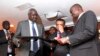 South Sudan's leader of the government's delegation Nhial Deng Nhial (L) exchanges a signed ceasefire agreement with the head of the rebel delegation Gen. Taban Deng Gai (R) to end more than five weeks of fighting after negotiations in Ethiopia's capital 
