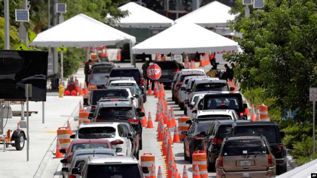 FILE - Lines of cars wait at a drive-through coronavirus testing site outside the Miami Beach Convention Center, in Miami Beach, Florida, June 26, 2020. 
