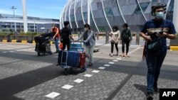 旅客們推著行李進入新加坡樟宜機場的離境大廳。 （2021年8月19日） 