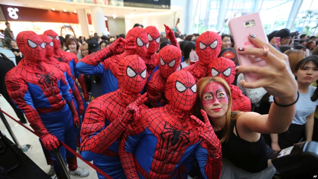 Event workers wearing Spider-Man costumes pose for a selfie for a fan during a promotional event for the film "Spider-Man: Homecoming" in Seoul, South Korea, Sunday, July 2, 2017. 