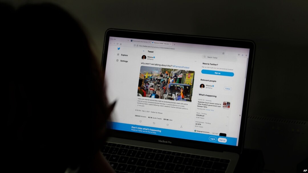 FILE - A woman looks at the Twitter page of pop star Rihanna in New Delhi, India, July 15, 2021.