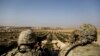 American troops look out toward the border with Turkey from a small outpost near the town of Manbij, northern Syria, Feb. 7, 2018. 