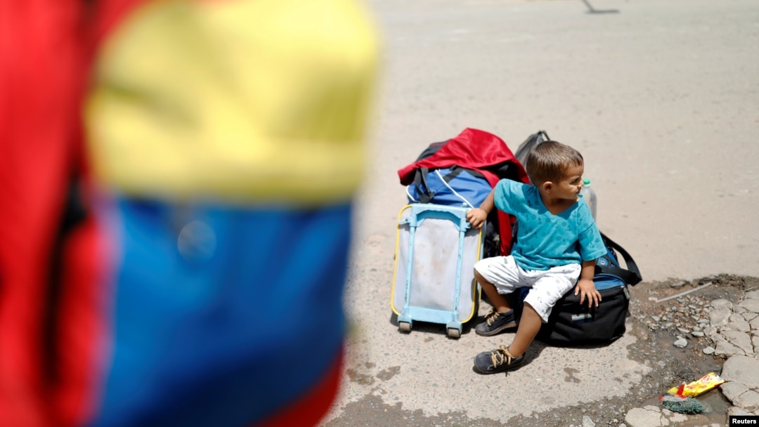 A Venezuelan boy sits next to family belongings at the Pacaraima border control, Roraima state, Brazil, Aug. 20, 2018. 