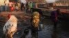 A women (R) displaced by the fighting in Bor county washes herself as another washes kettles, in the village of Mingkamen, in South Sudan, Jan. 14, 2014.