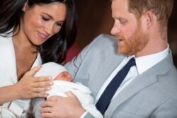 FILE - Britain's Prince Harry and Meghan, Duchess of Sussex, hold their baby son in St. George's Hall at Windsor Castle, in Berkshire, Britain, May 8, 2019.