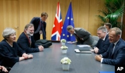 FILE - European Council President Donald Tusk, right, meets with British Prime Minister Theresa May, left, during a bilateral meeting on the sidelines of an EU summit in Brussels, Belgium, June 22, 2017. Brexit talks in Brussels are now deadlocked.