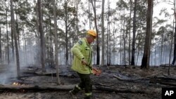 Forestry Corporation worker Dale McLean patrols a controlled fire at a wildfire near Bodalla, Australia, Jan. 12, 2020.