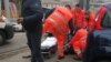 Health care personnel help an injured person after being wounded by gunfire from a vehicle in Macerata, Italy, Feb. 3, 2018. 