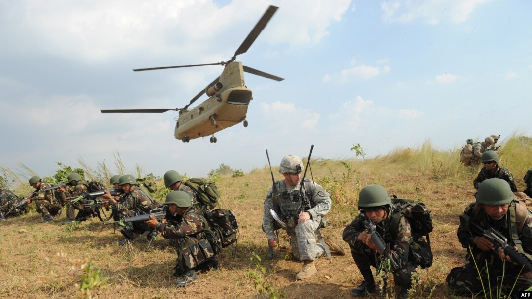 FILE - Philippine soldiers and a U.S. Army soldier from 2nd Stryker Brigade Combat of the 5th Infantry Division based in Hawaii take their positions after disembarking from a C-47 Chinook helicopter during an air assault exercise inside the military training camp of Fort Magsaysay in Nueva Ecija province north of Manila, April 20, 2015, at the start of joint U.S.-Philippines annual military exercises. 
