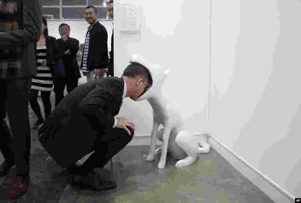 A man looks at an art installation &quot;Face To Face&quot; created by Taiwan artist Peng Hung-chih during the VIP preview of the art fair &quot;Art Basel&quot; in Hong Kong, March 22, 2016.