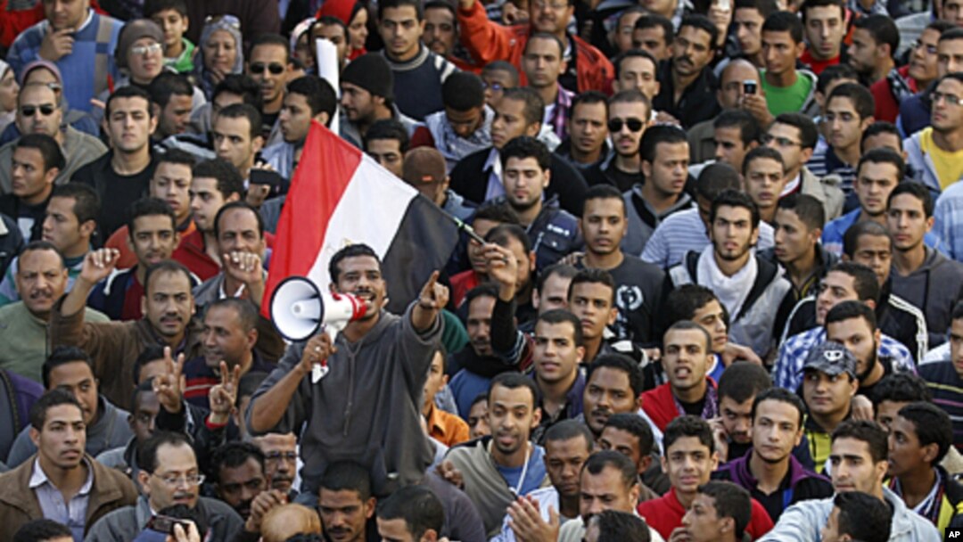 A demonstrator uses a portable loudspeaker as he shouts slogans against the military council during a mass protest in Alexandria, in support of mass protests in Tahrir square in Cairo, November 25, 2011.