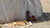 A girl sits outside a tent at al-Wara camp for internally displaced people in al-Khukha of Hodeidah province, Yemen, Nov. 21, 2021.